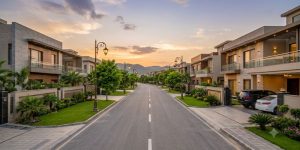 Luxury residential boulevard in Zaraj Housing Society Islamabad at golden hour with modern villas and Margalla Hills